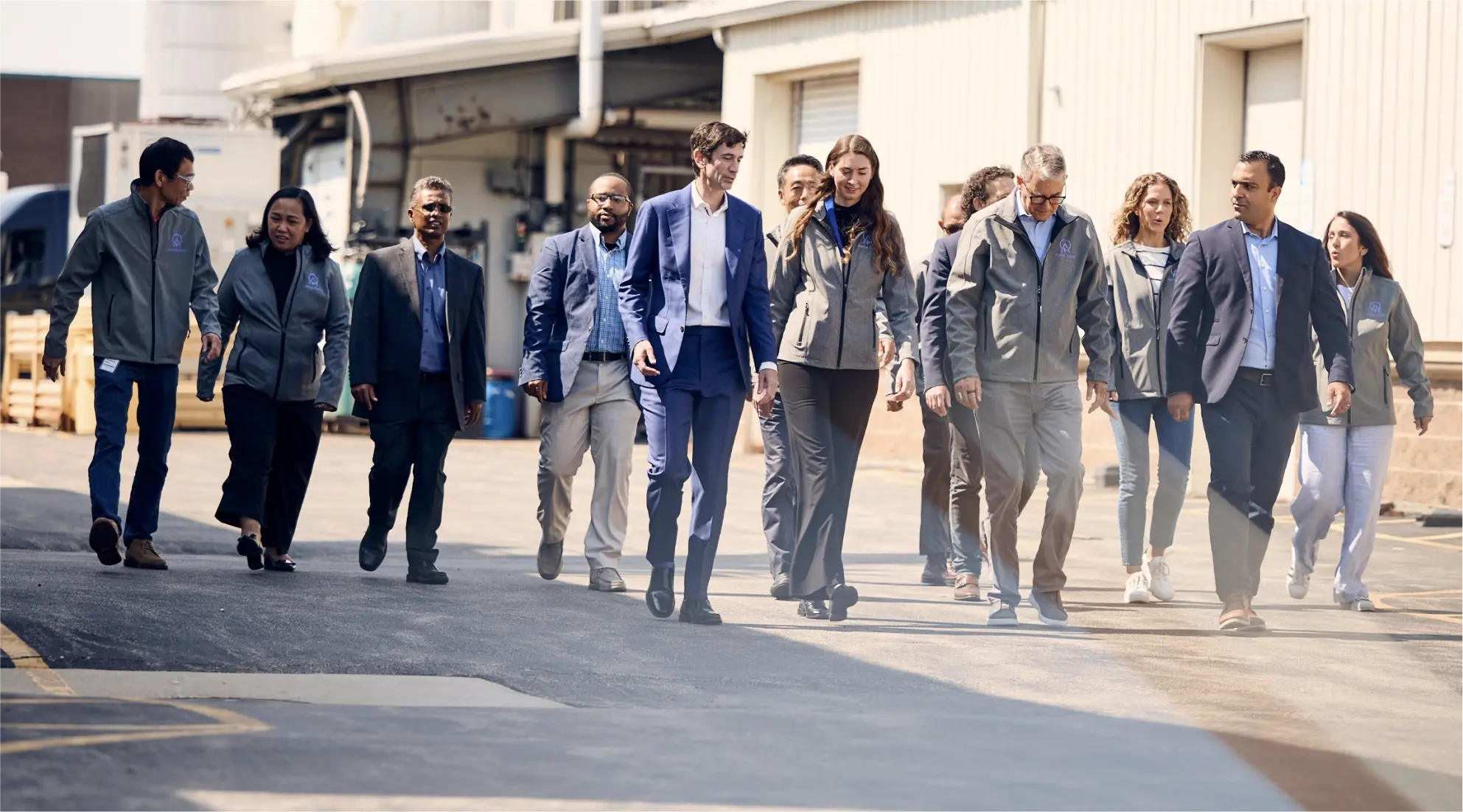 A group of people walking towards the camera next to a building